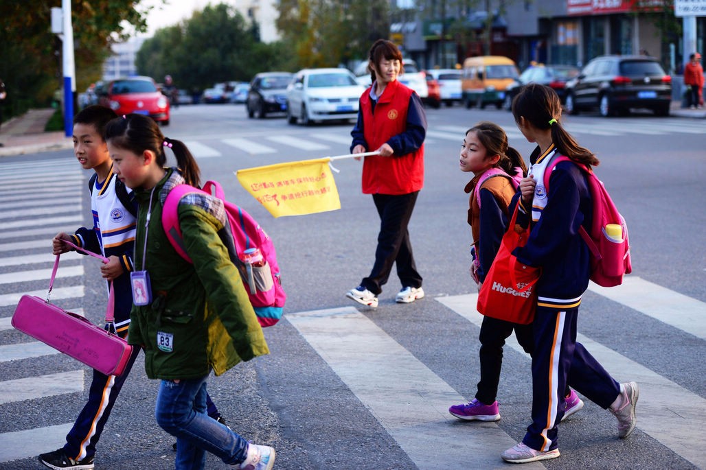青岛西海岸新区公交司机下班后当志愿者 护送孩子过马路 当赞