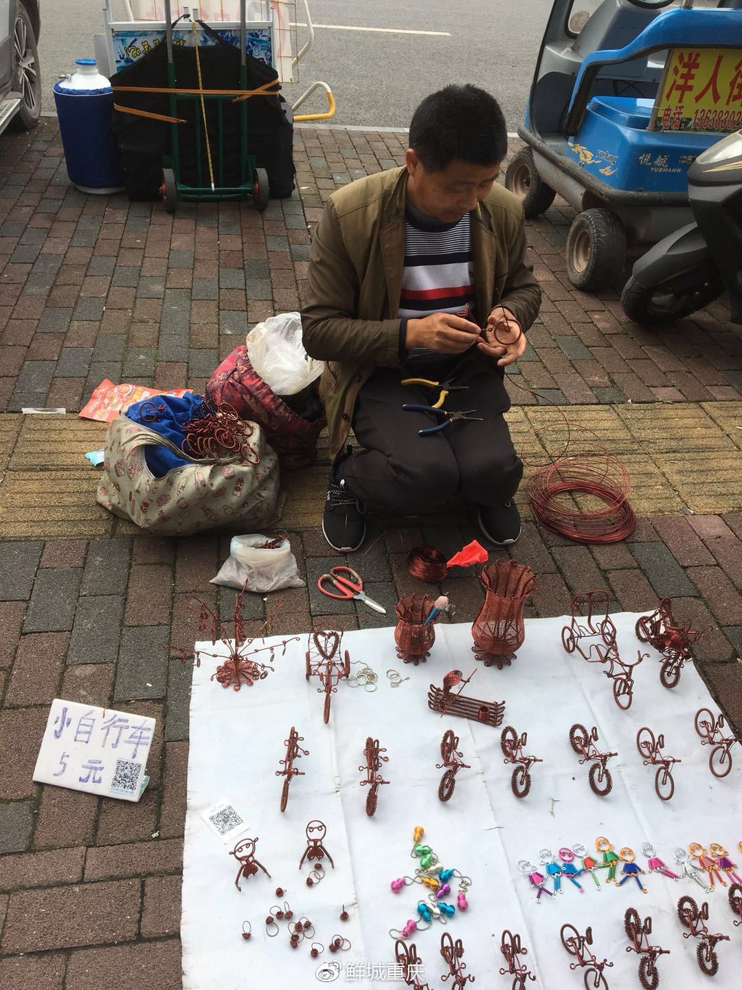 每一个都很有意思有自行车,花瓶,小人儿一个手工小摊,老板正在用铜丝