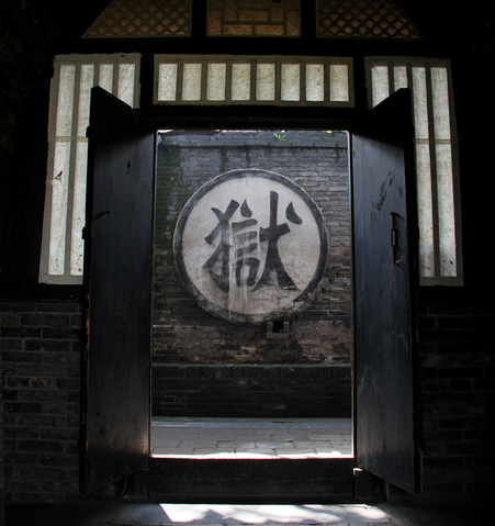 进门后的墙上悬挂着的刑枷.牢房.