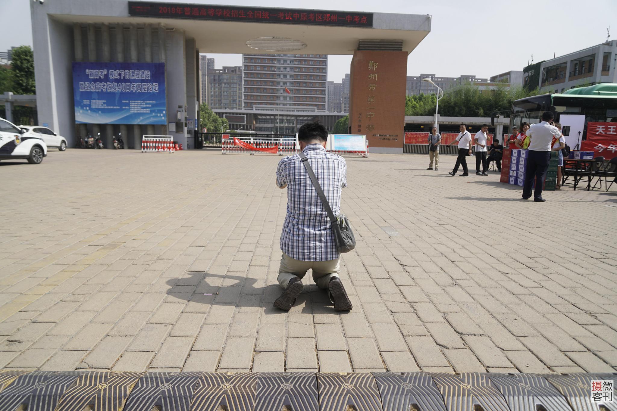 孩子二度进考场 父亲朝考场方向下跪祈祷