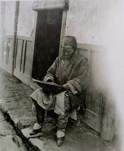 这张照片中是路边的一位老太太在拣茶叶,从衣着上就可以看出生活十分