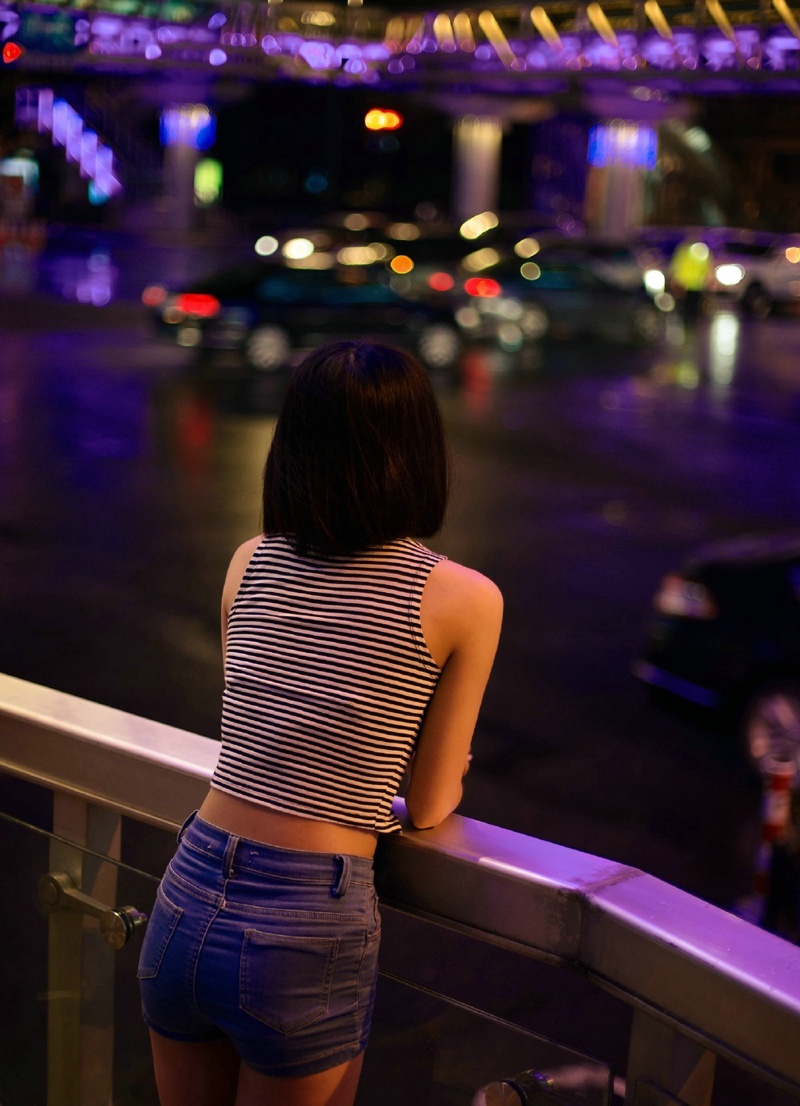 夜晚街头上的背心牛仔裤少女寂寞写真