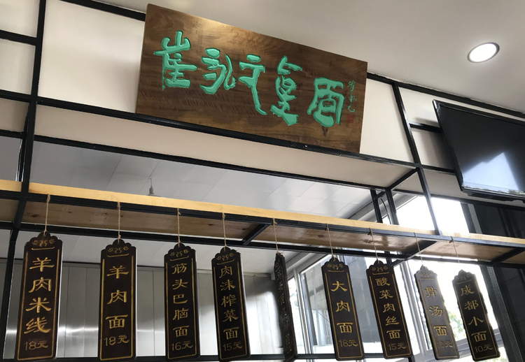 从图中不难看出,牌匾是崔永元亲手写下的,菜名写在木板上悬挂在档口