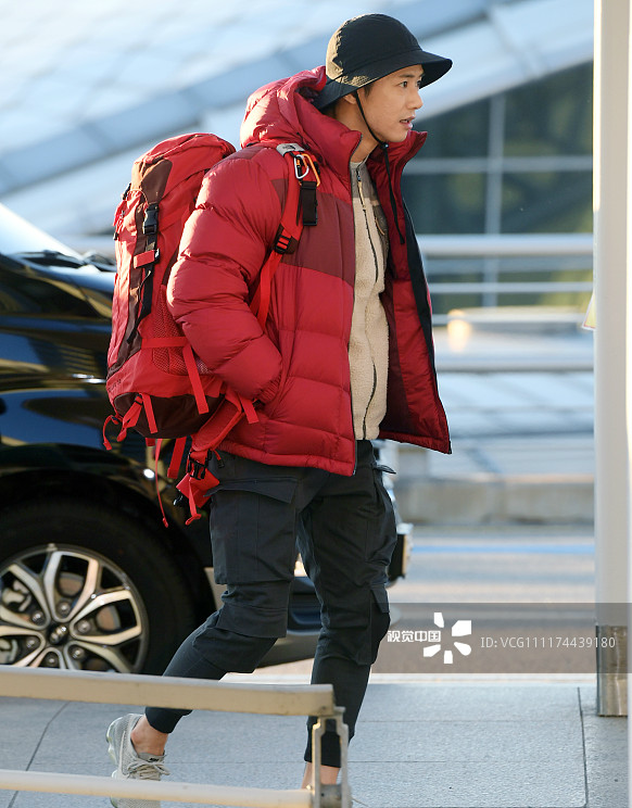 歌手吴钟赫穿大红色羽绒服包裹严实机场背着双肩包活力满满