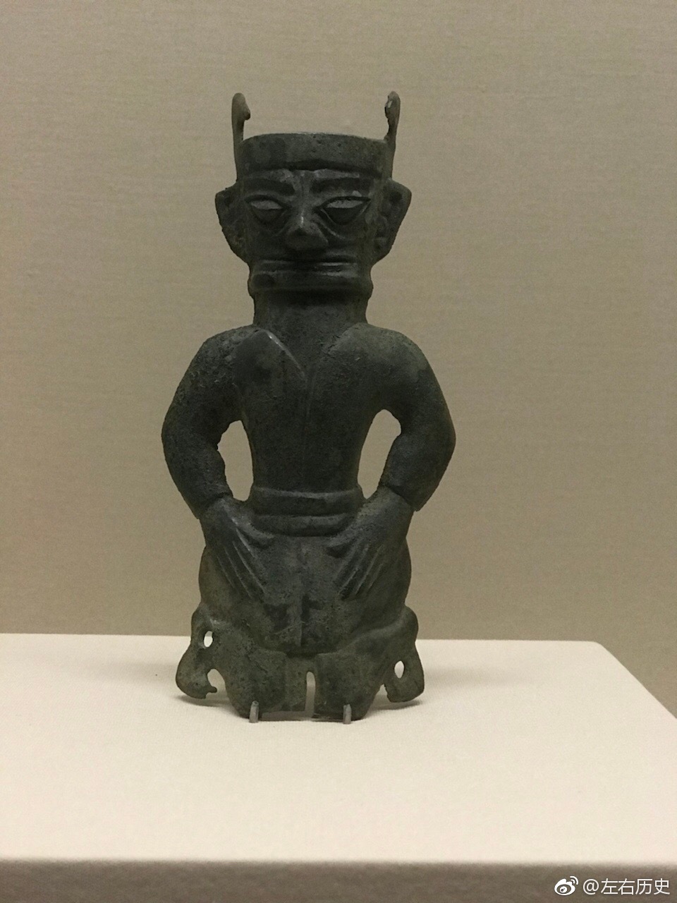 图一二为跪坐青铜人像戴有頍饰身穿对襟长袖衣双手置于胯前