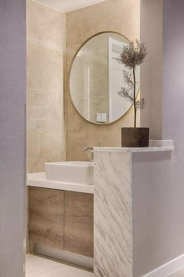 卫生间干区以矮墙隔断,上面摆一盆干枝,搭配大圆镜,显得开放而又时尚