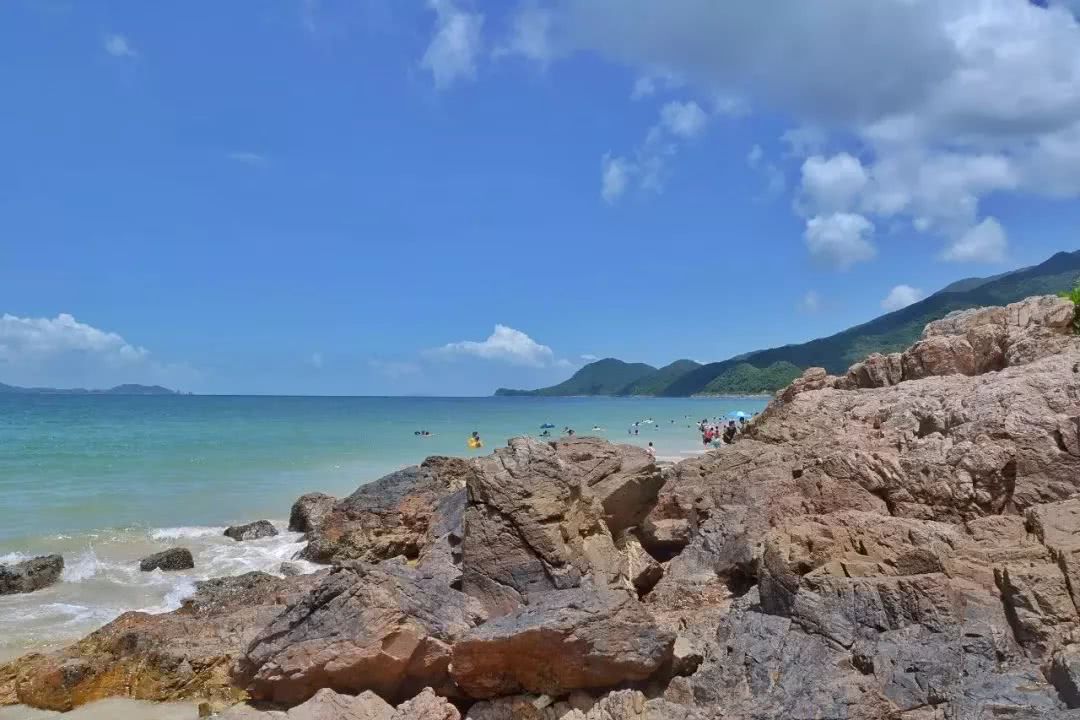 顺着潮起潮落感受海的力量游客在沙滩边游泳嬉戏这里的海水清澈天空