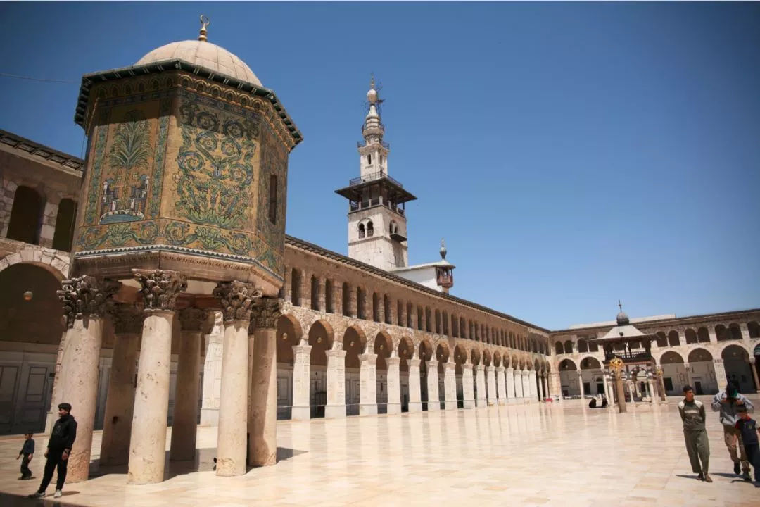 在塔下合影 他还拜访了叙利亚的大马士革城和伊斯兰教的倭马亚清真寺