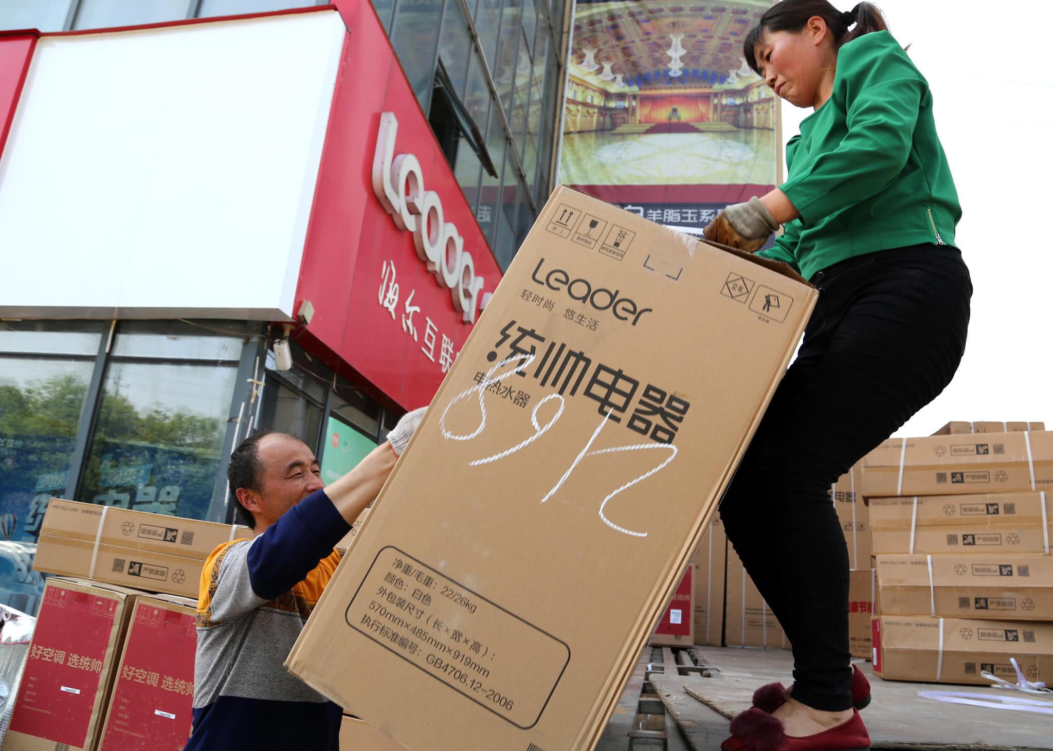 某电器专卖店送货的搬运工正在装车,"在旺季到来的时候不分那女干的活