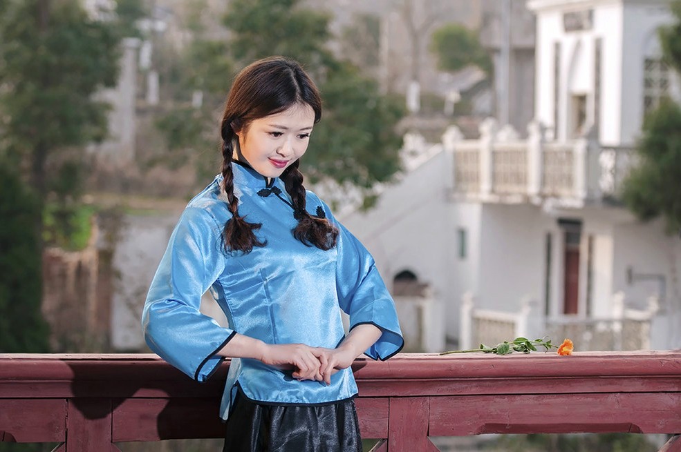 一个衣着旧时代装的可爱小辫子姑娘