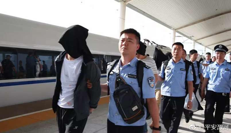 高铁站,在外地征战数月,风尘仆仆的专案民警押解着21名头戴黑色头套的