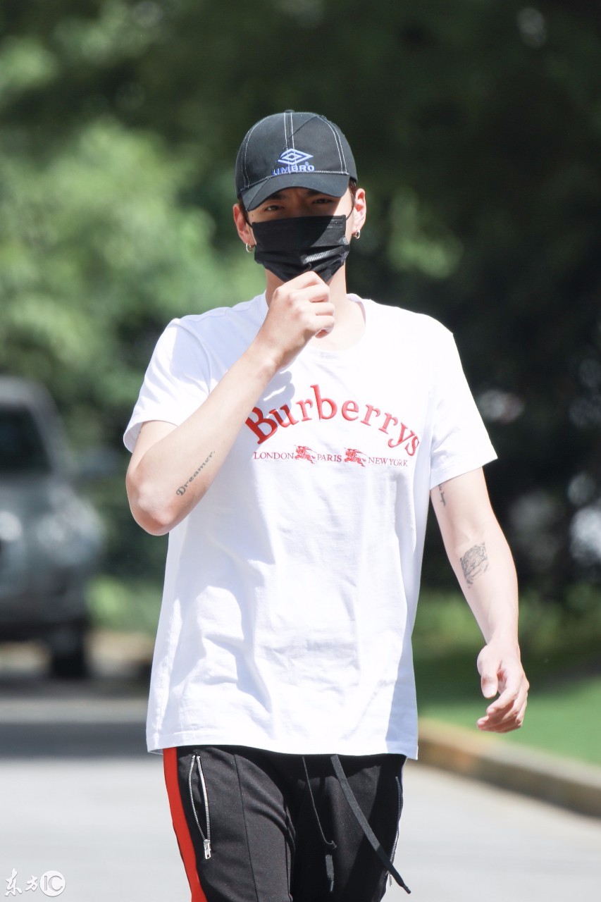 吴亦凡戴棒球帽和口罩穿白t搭配黑运动裤现身,见镜头挥手打招呼