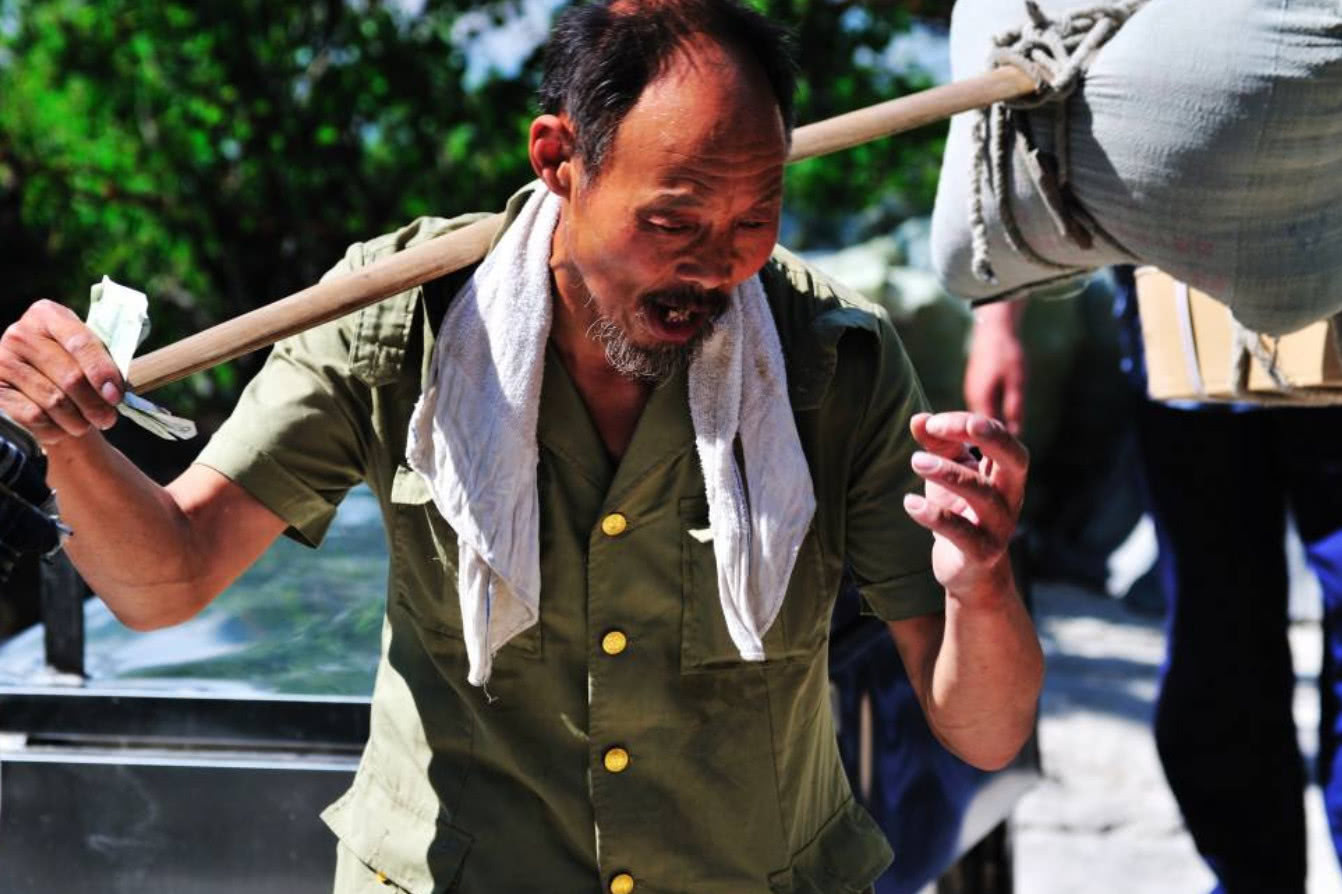 华山上的棒棒军吃冷馒头穿脏衣服住茅棚里挑一斤挣5毛血汗钱
