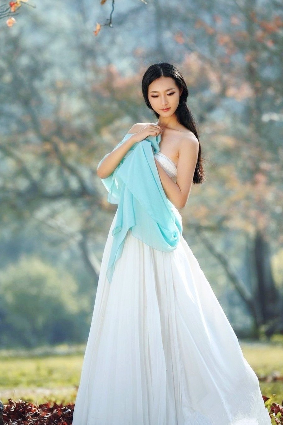 透过树林阳光下的一个温柔漂亮女子