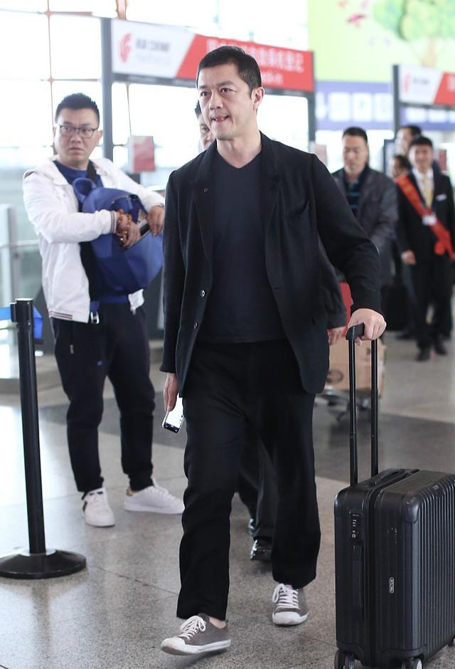 李亚鹏西装配球鞋造型休闲帅气一路看手机低头露满脸褶子