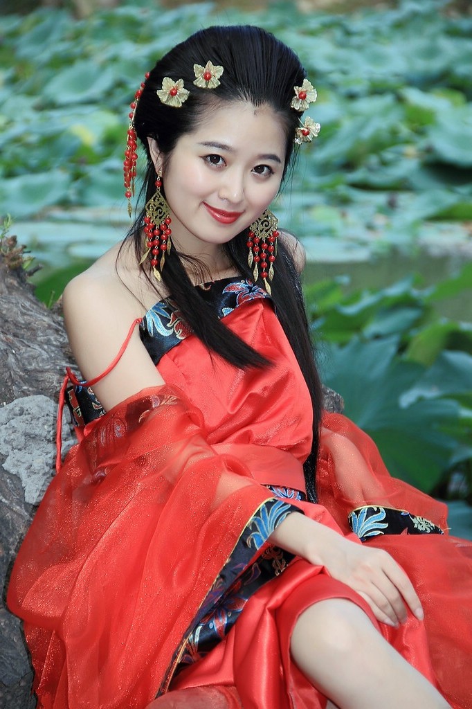 荷花池边一个有着民族红色古韵装的女子