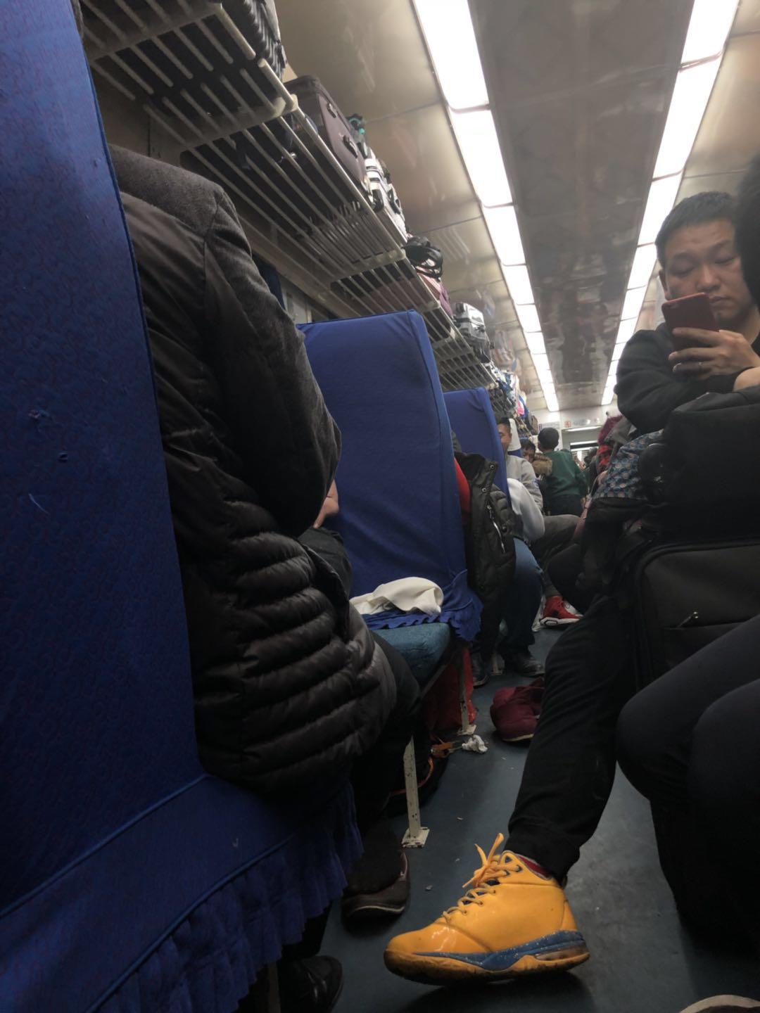 春运期间在拥挤的绿皮火车厢内母亲彻夜不眠也要让孩子睡好