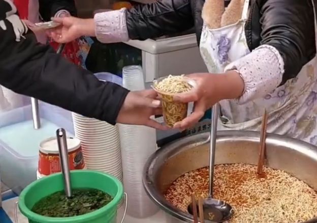大妈学校门口卖"泡面",1块钱1杯,摊位围满了学生,大人都去