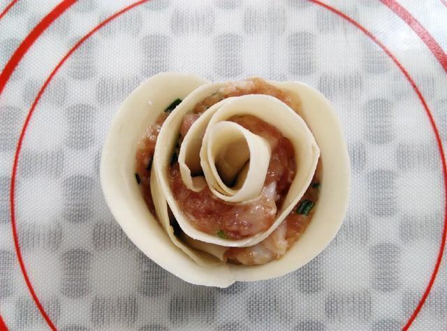 卷好的玫瑰花饺子边上沾一点水,让饺子皮黏合,一朵含苞欲放的漂亮玫瑰
