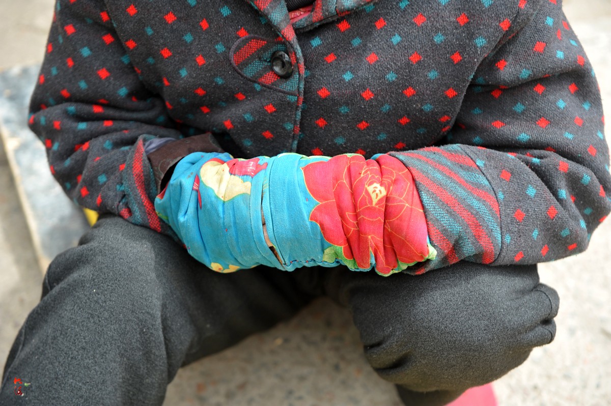 的天气乍暖还寒,老人戴了一副棉套袖,冷的时候就把双手伸进套袖里保暖