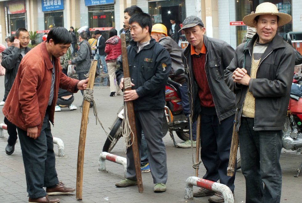 他们是最底层的劳苦大众,靠一根棍棒养家糊口,爬坡越坎负重前行