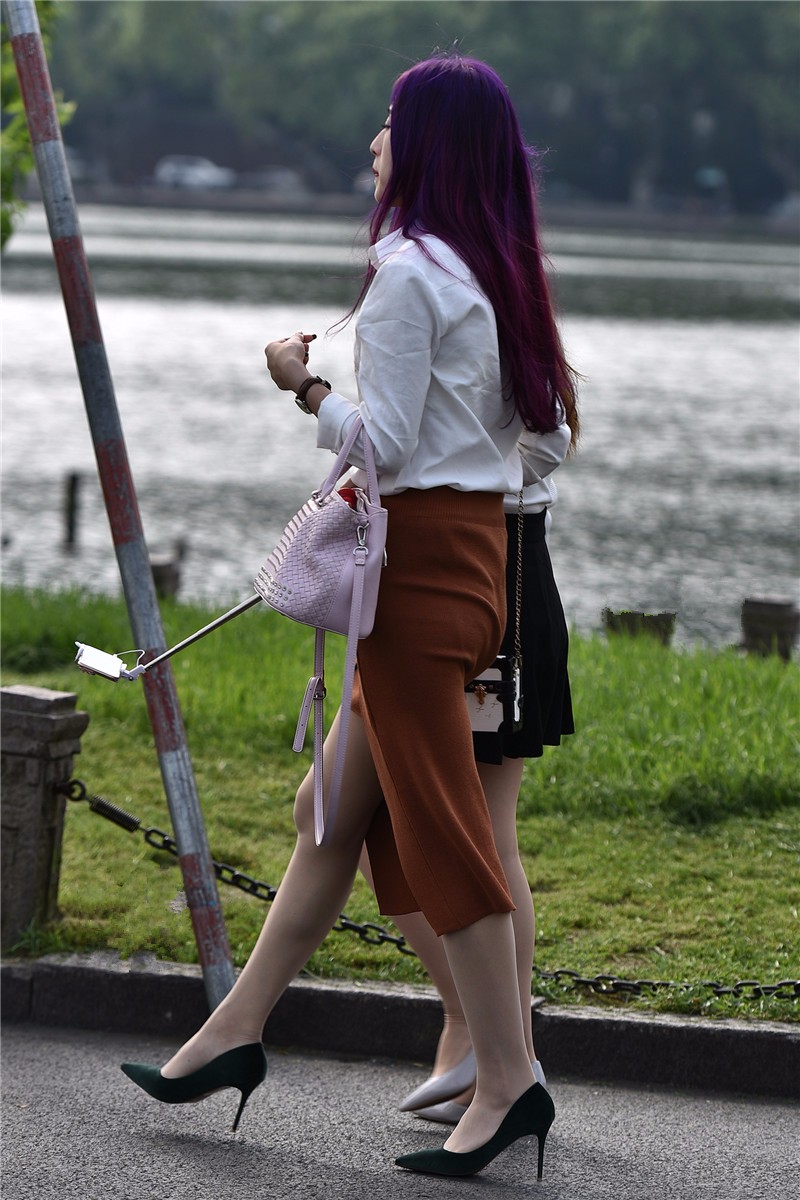 路人街拍拿着自拍杆自拍的紫发高个美女和好闺蜜一起来郊游