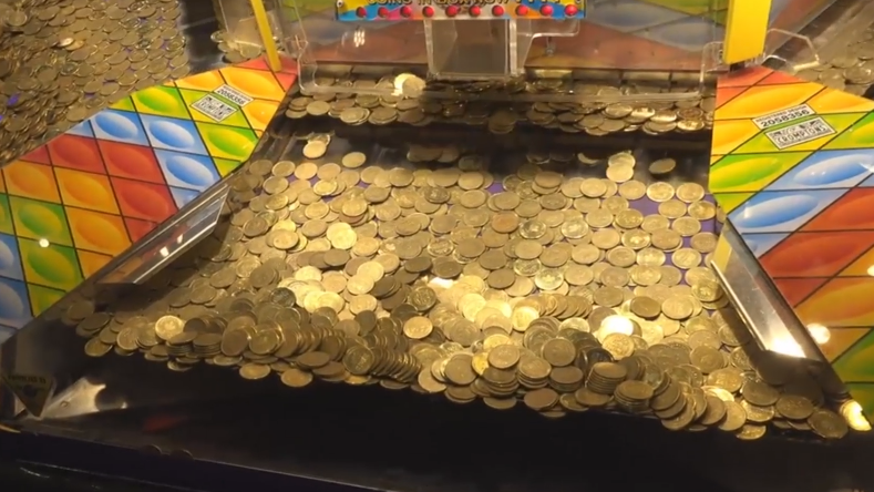 游戏厅的推币机,为什么投很多币都掉不下来?原