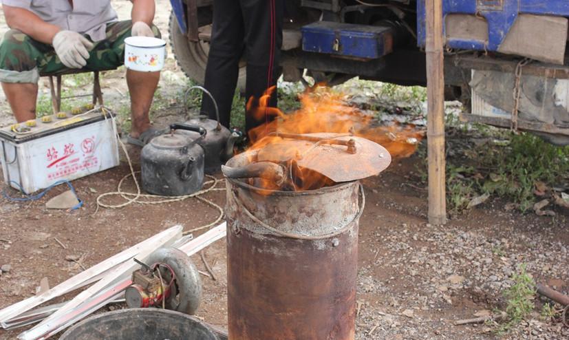父亲将一些废铝器皿敲碎,压扁,这样便于熔炉化铝.