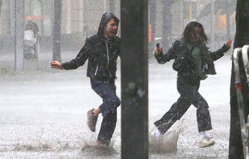 行人在街上奔跑躲雨