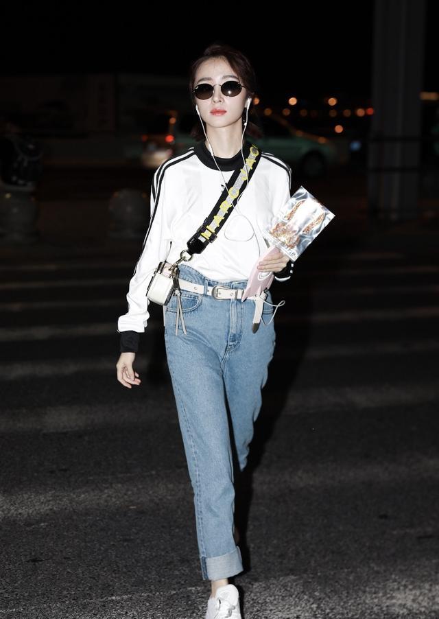 胡冰卿戴墨镜穿白卫衣搭配蓝色牛仔裤现身机场皮肤白皙面带微笑