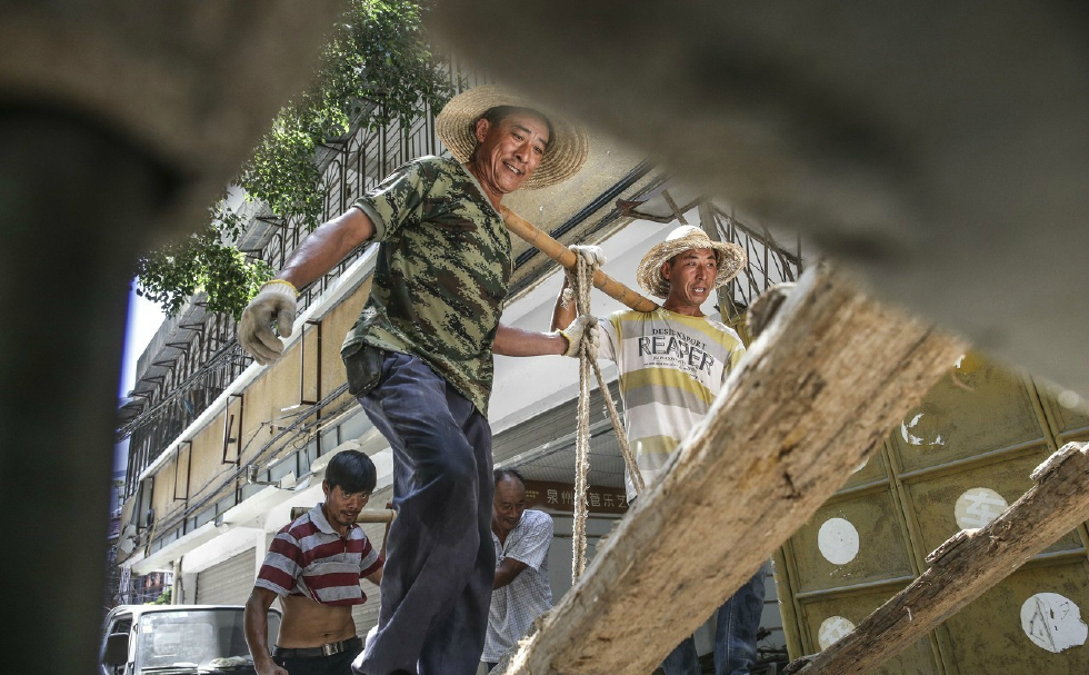 他们是最底层的劳苦大众,靠一根棍棒养家糊口,爬坡越坎负重前行