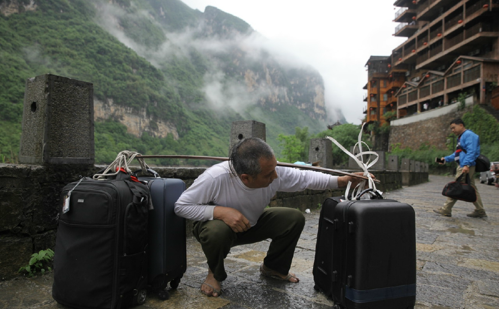 他们是最底层的劳苦大众靠一根棍棒养家糊口爬坡越坎负重前行