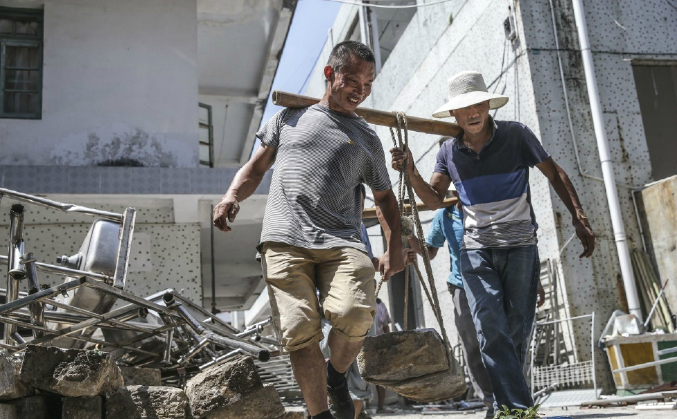 他们是最底层的劳苦大众,靠一根棍棒养家糊口,爬坡越坎负重前行