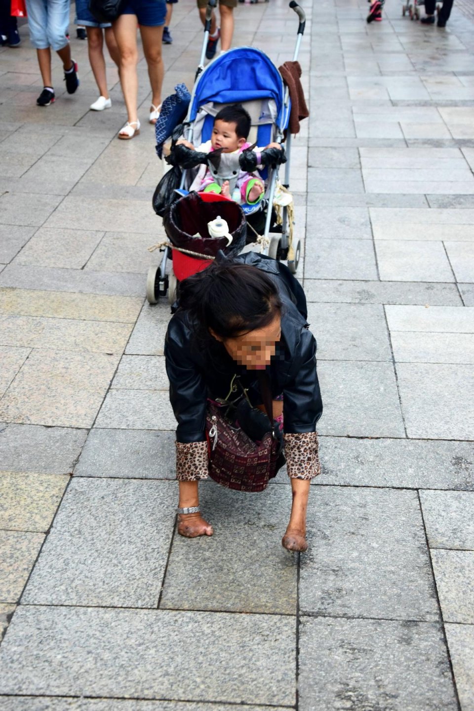 残障女士用小臂膝盖爬行拉着婴儿车乞讨,路人全绕着走,是冷血吗