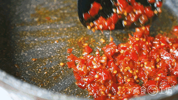 鱼头腌制好后放入盘中,下面用筷子垫着,浇上炒好的青红辣椒酱.