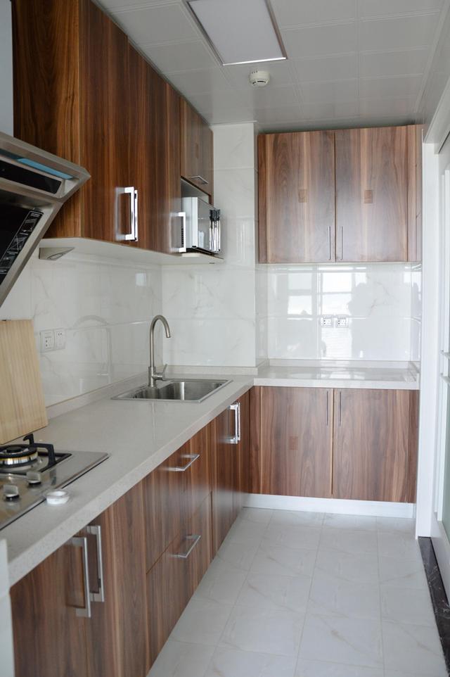 厨房内部空间不大,做的l形设计,墙砖和地砖都是一样的花色,白色带点