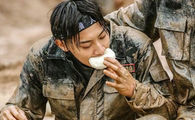 黄子韬蹲着吃包子,毫不在意一身的泥巴