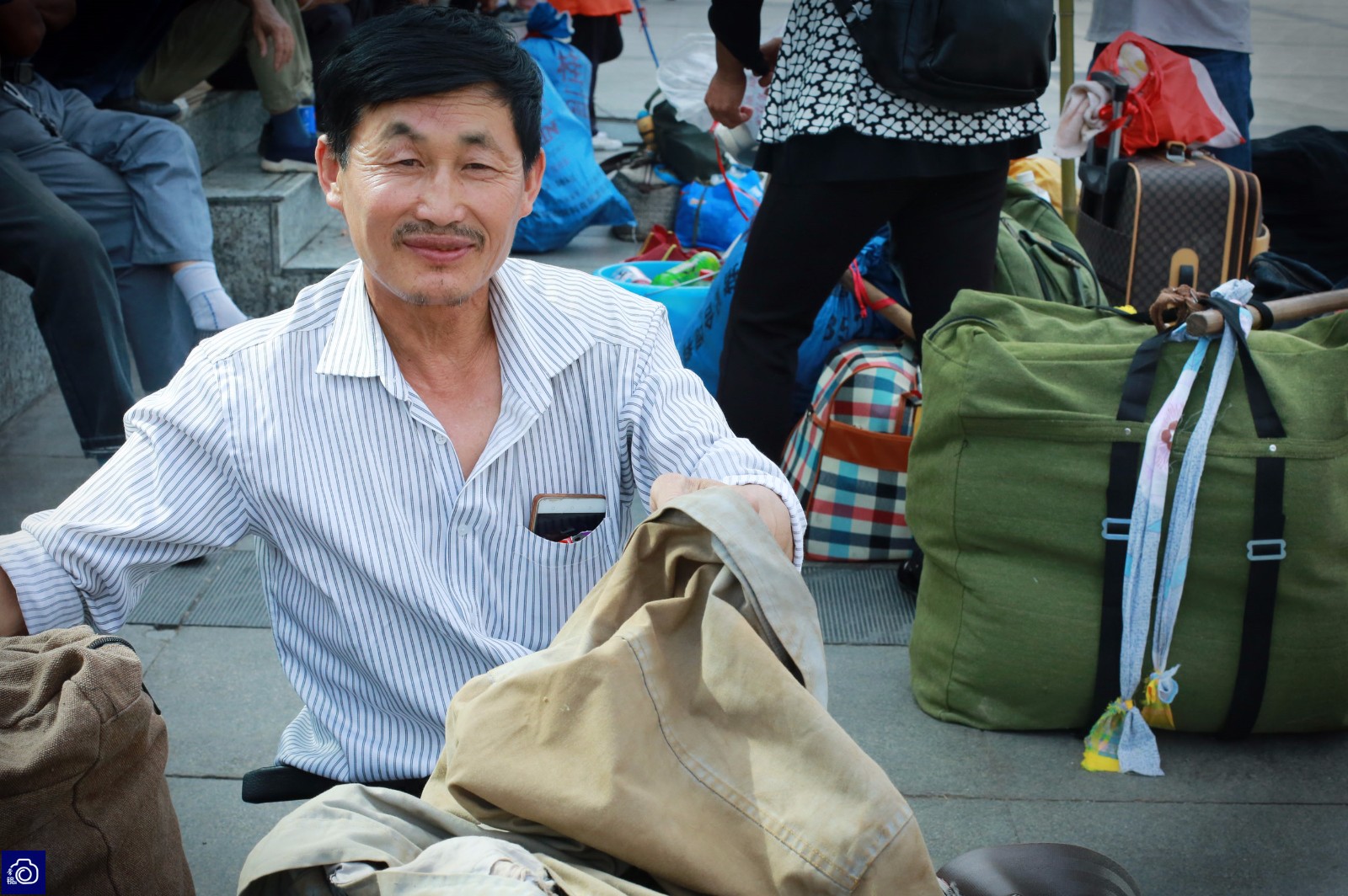 9名民工车站广场扎堆换新衣服,风风光光返乡收麦