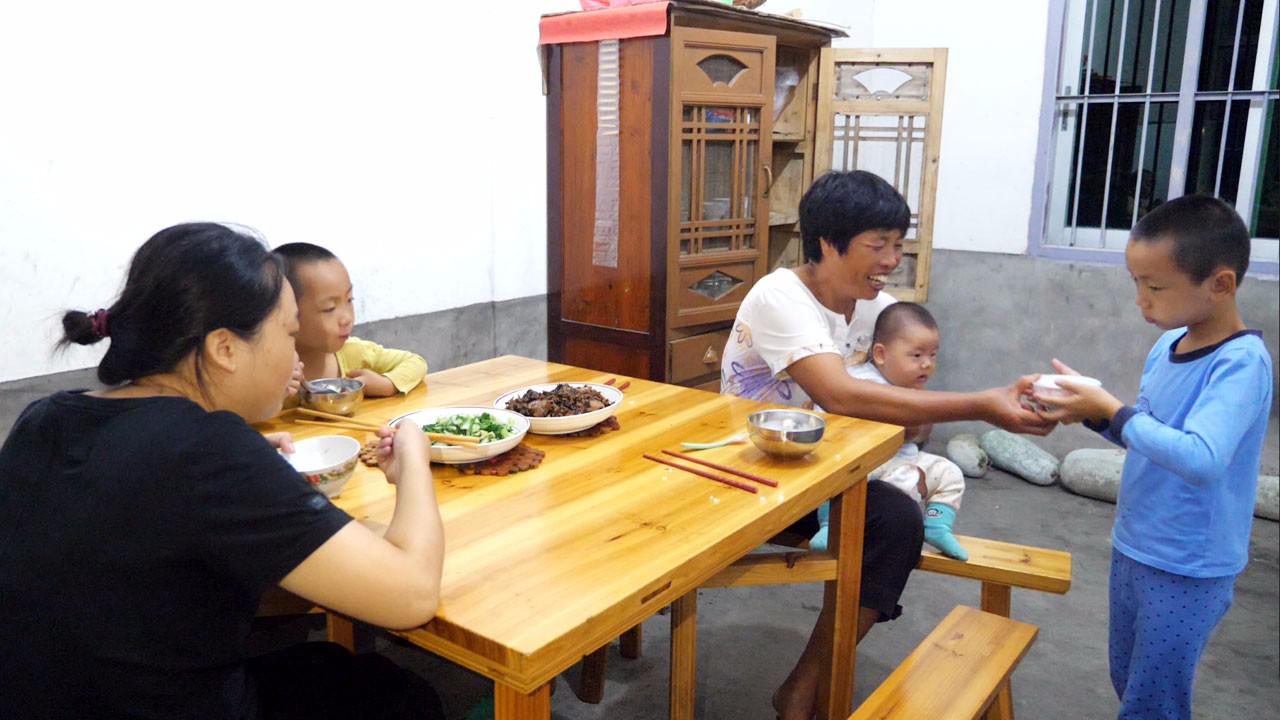 农村一家人正在吃饭,婆婆抱宝宝不方便盛饭,儿子的表现让人称赞