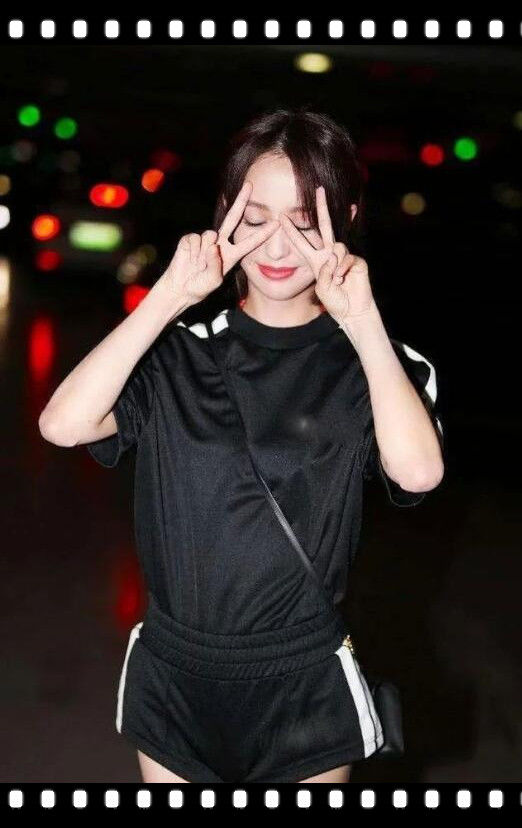 半眯着双眼,高高的鼻梁五官非常立体,两只手在脸上比出v手势,典型的