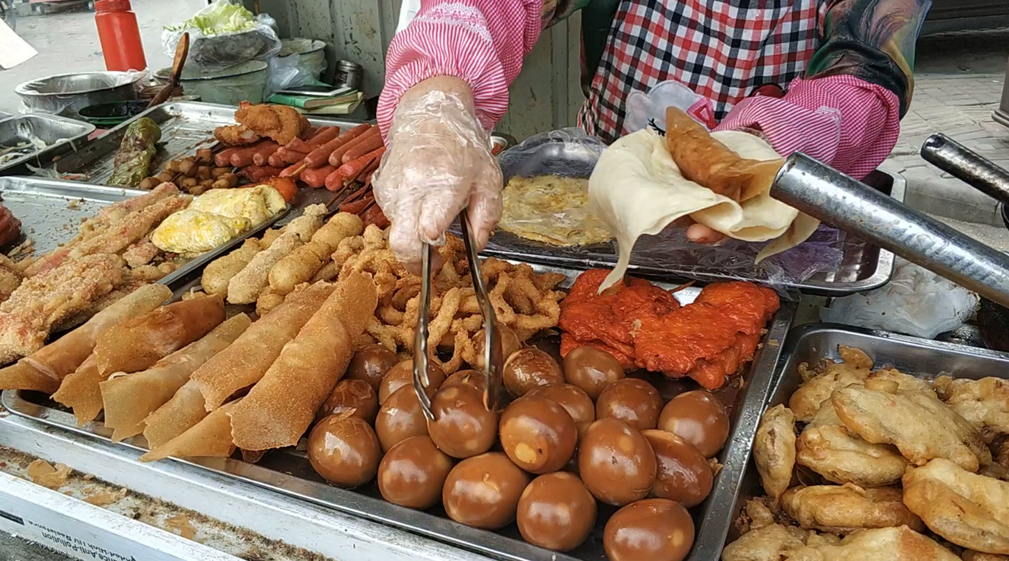 到天津必吃的早点之大饼夹一切,手掌大的鸡排只要6元