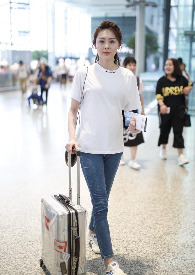 黄梦莹穿白色t恤搭配蓝色牛仔裤现身机场皮肤白皙笑容甜美