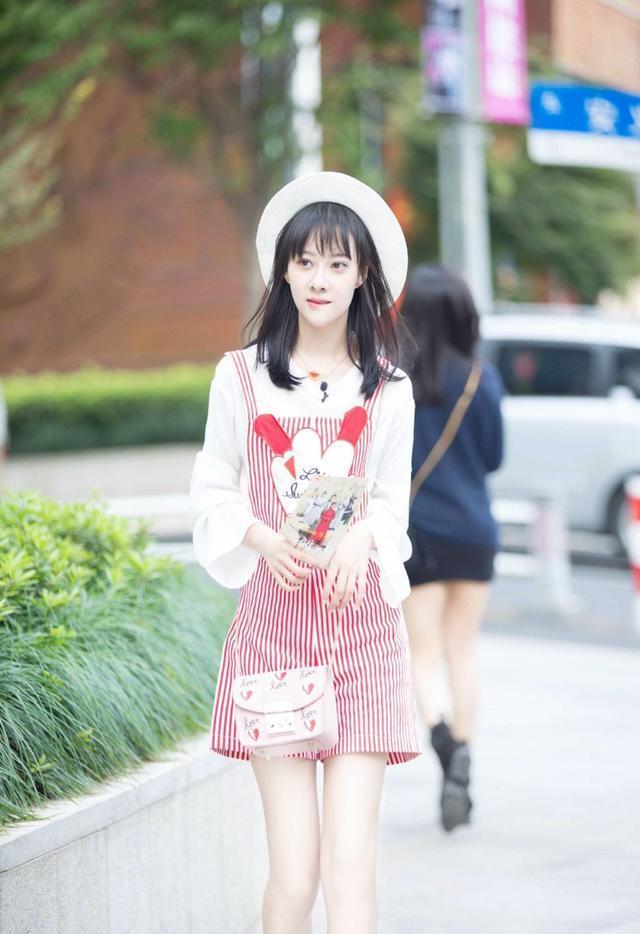 曹曦月内搭一件白色的半袖,外面搭配上一条黑白相间的背带裤,脚上穿着