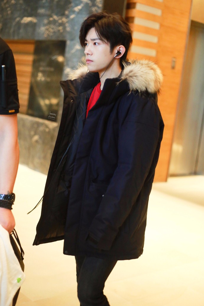 易烊千玺广州工作 羽绒服上身 红色毛衣格外显