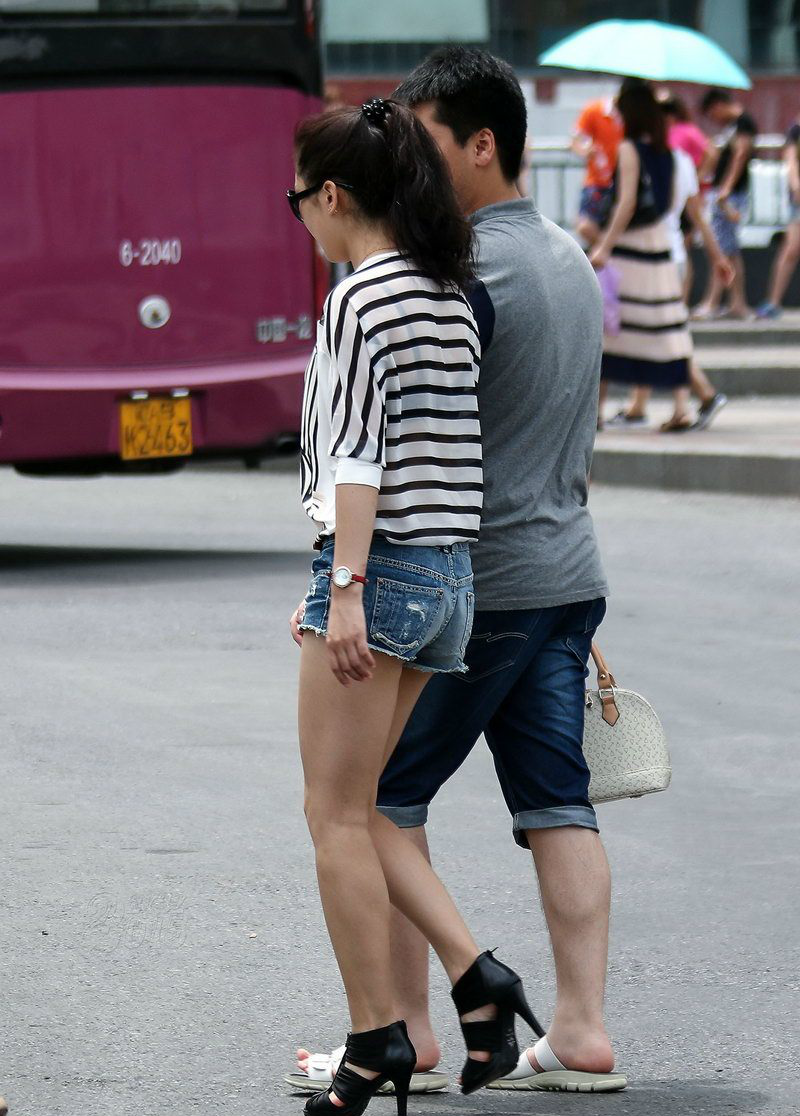 街拍广场遇见一位和男友逛街的牛仔短裤美女