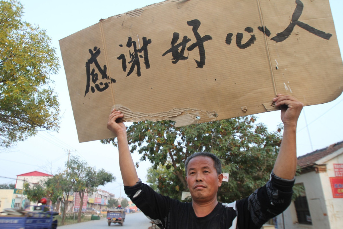 五旬老汉举牌"卖身"10万,神秘红衣女郎登门留钱走人