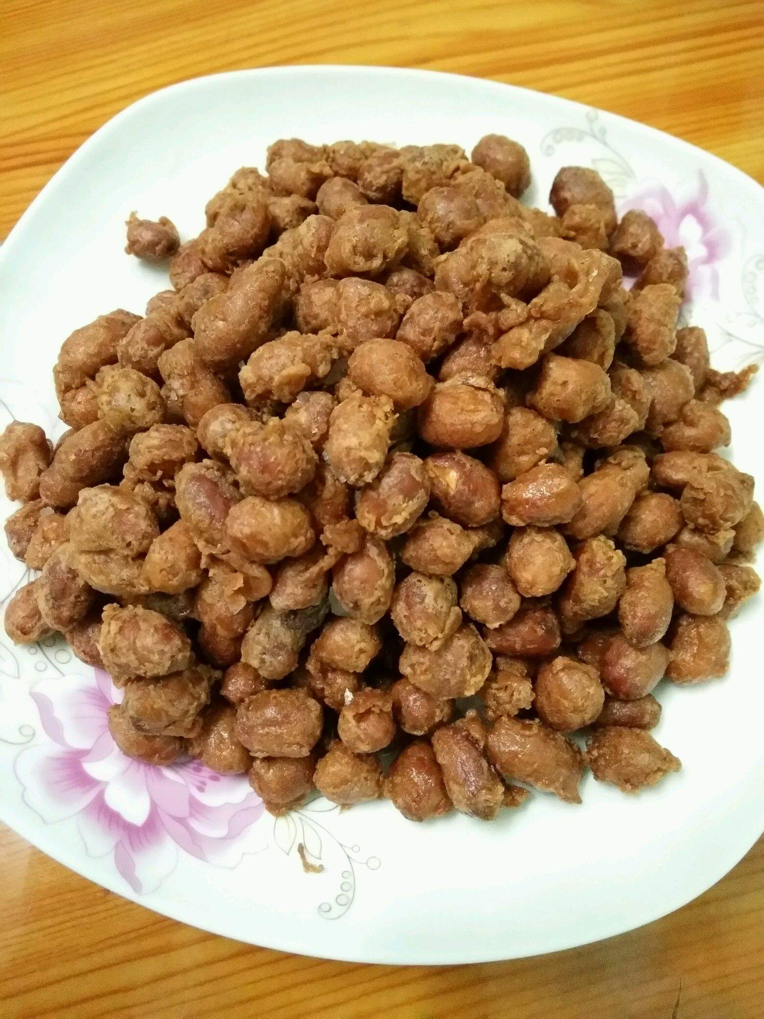 5,锅内烧油,油热后关小火把裹上面糊的花生米放入锅里炸,在炸的过程中