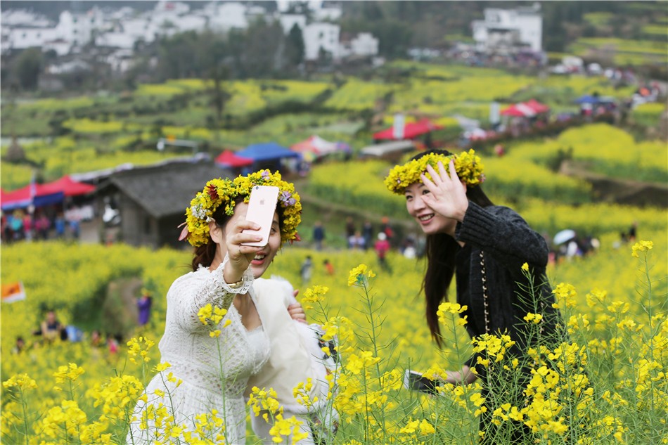 春天的婺源 油菜花盛开,姑娘头戴十元花环满山遍野拍照