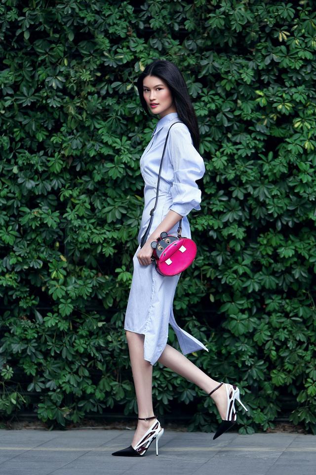 何穗穿着一袭红色的连衣裙,脚上穿着一双红色的高跟鞋,手里拎着一个