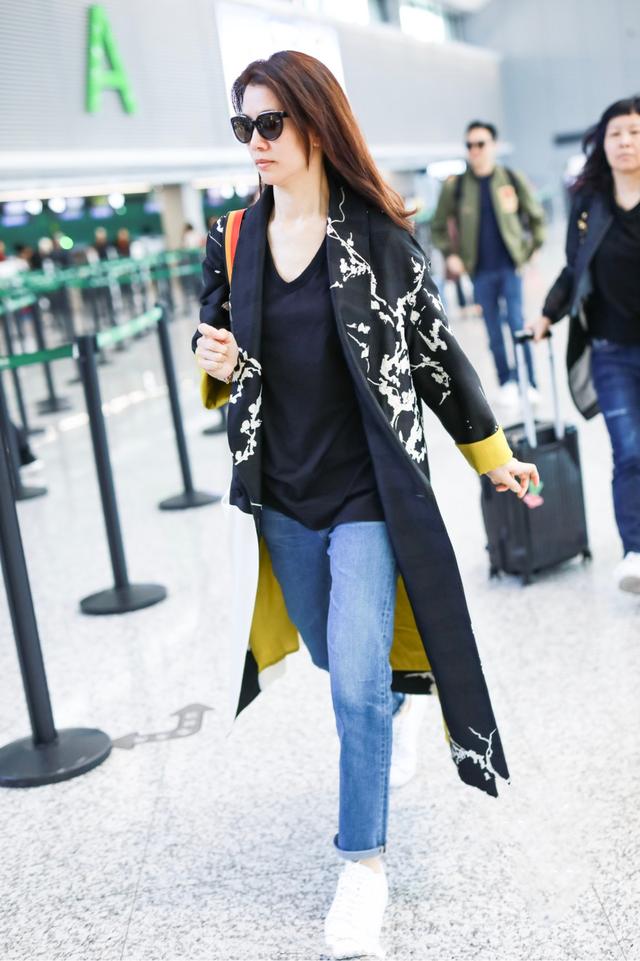 47岁袁咏仪机场罕见秀恩爱,穿印花大衣配小白鞋,美得忘了时间